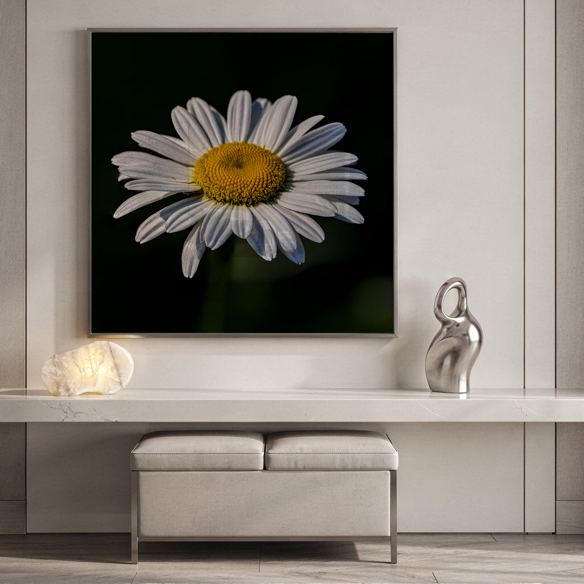 Framed picture of a daisy on a wall above a console table with decorative items.