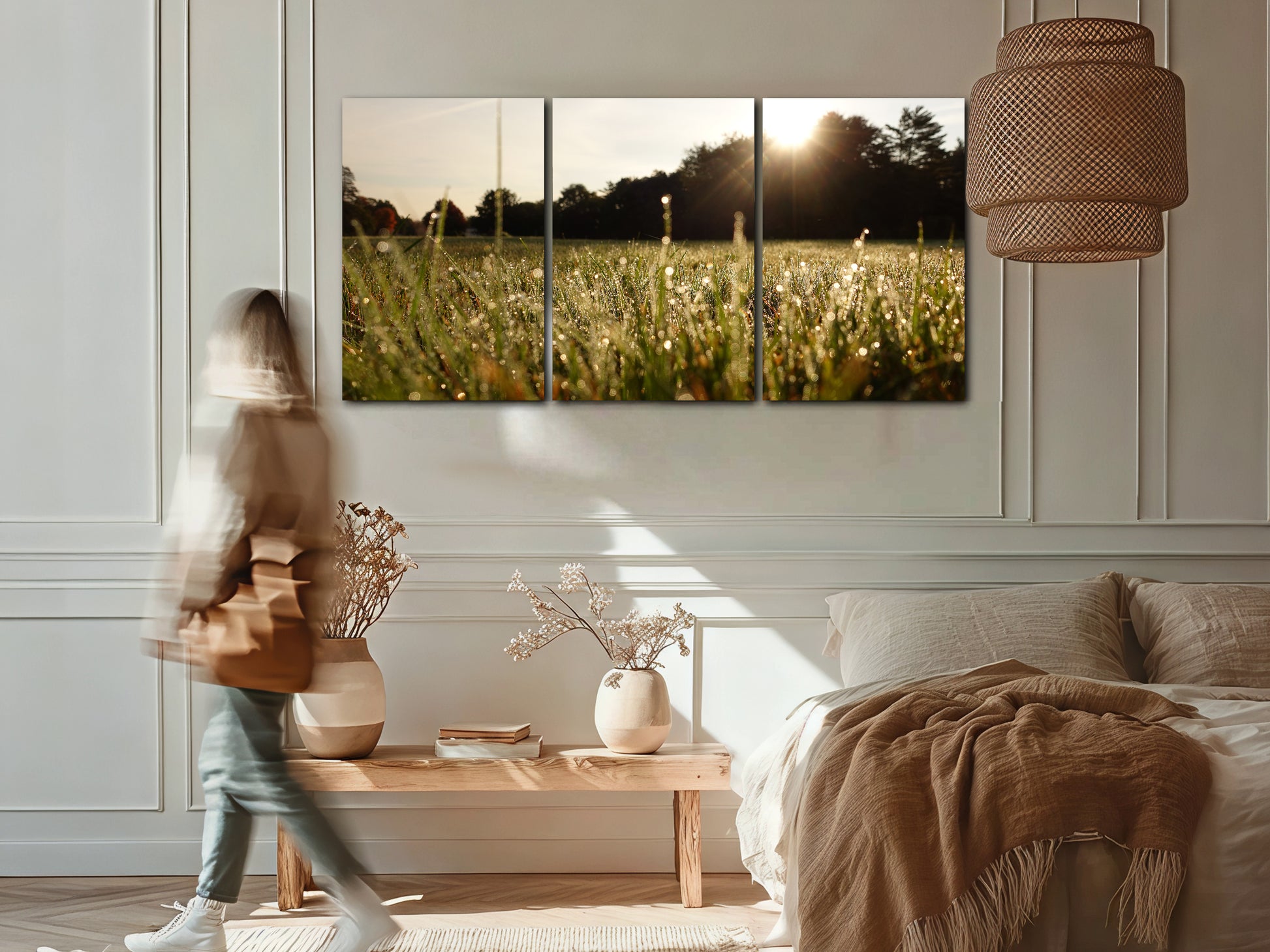 Three-panel wall art of a sunlit field in a bedroom setting with a person walking by.