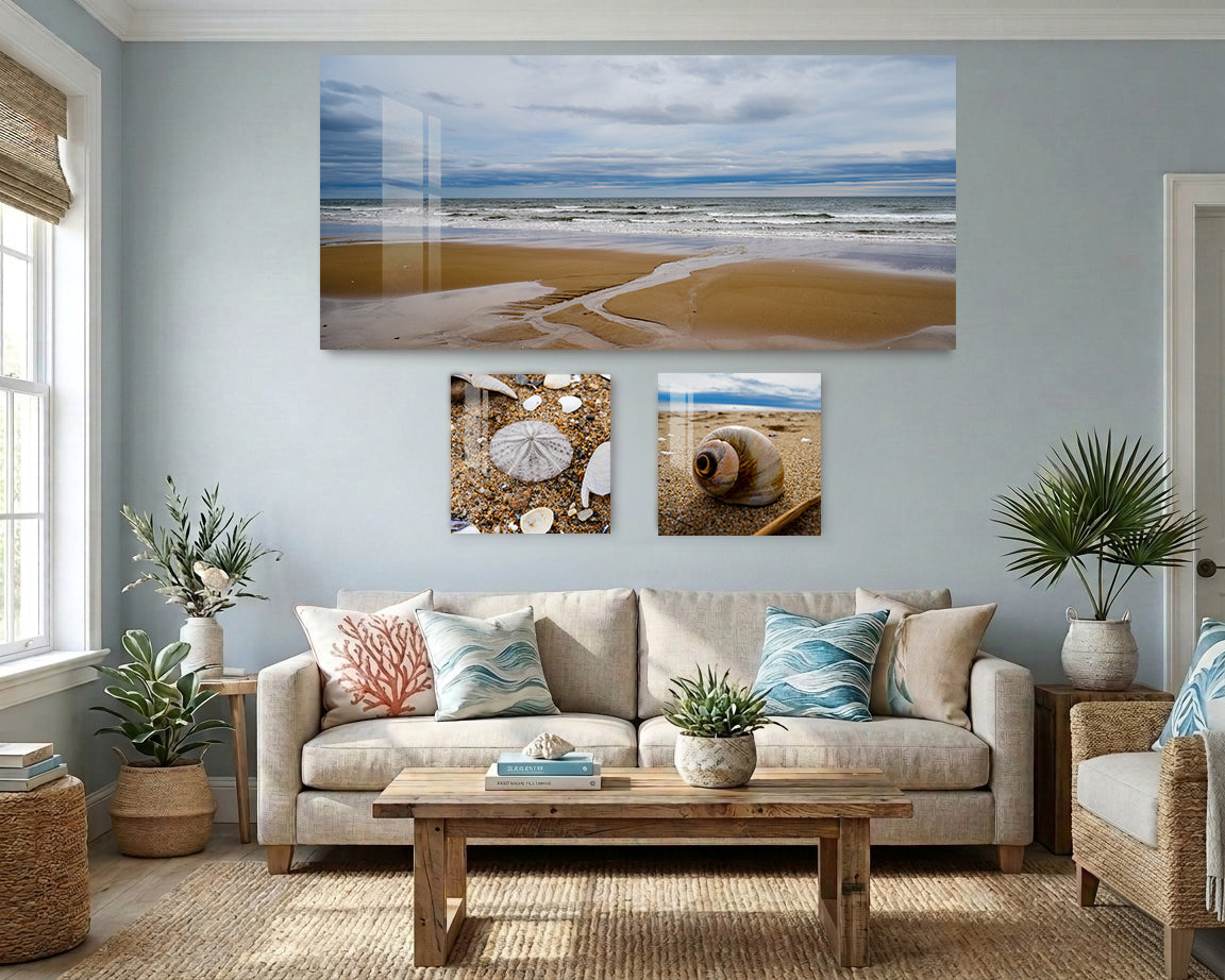 Living room with a beige sofa, wooden coffee table, and beach-themed wall art.